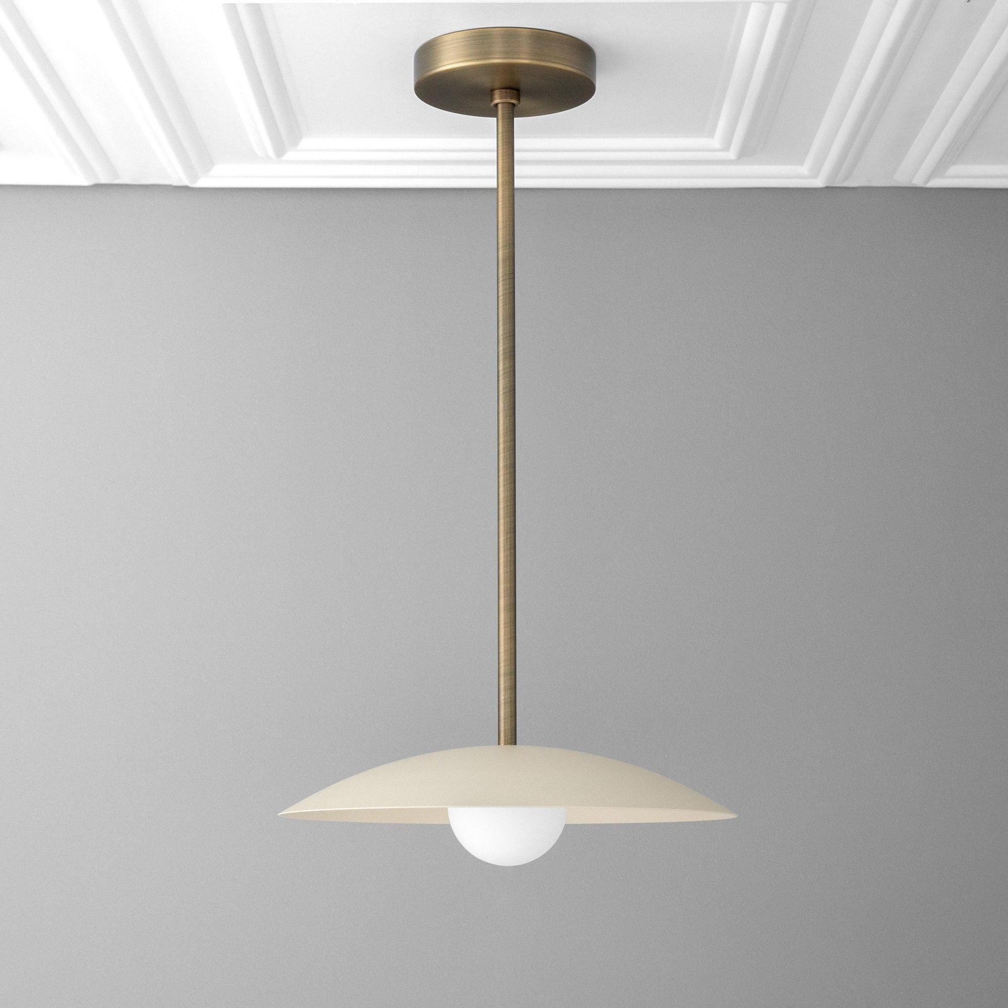 Mid-century modern antique brass pendant with cream flat dome shade and exposed globe bulb. - PENDANT MODEL NO. 4085