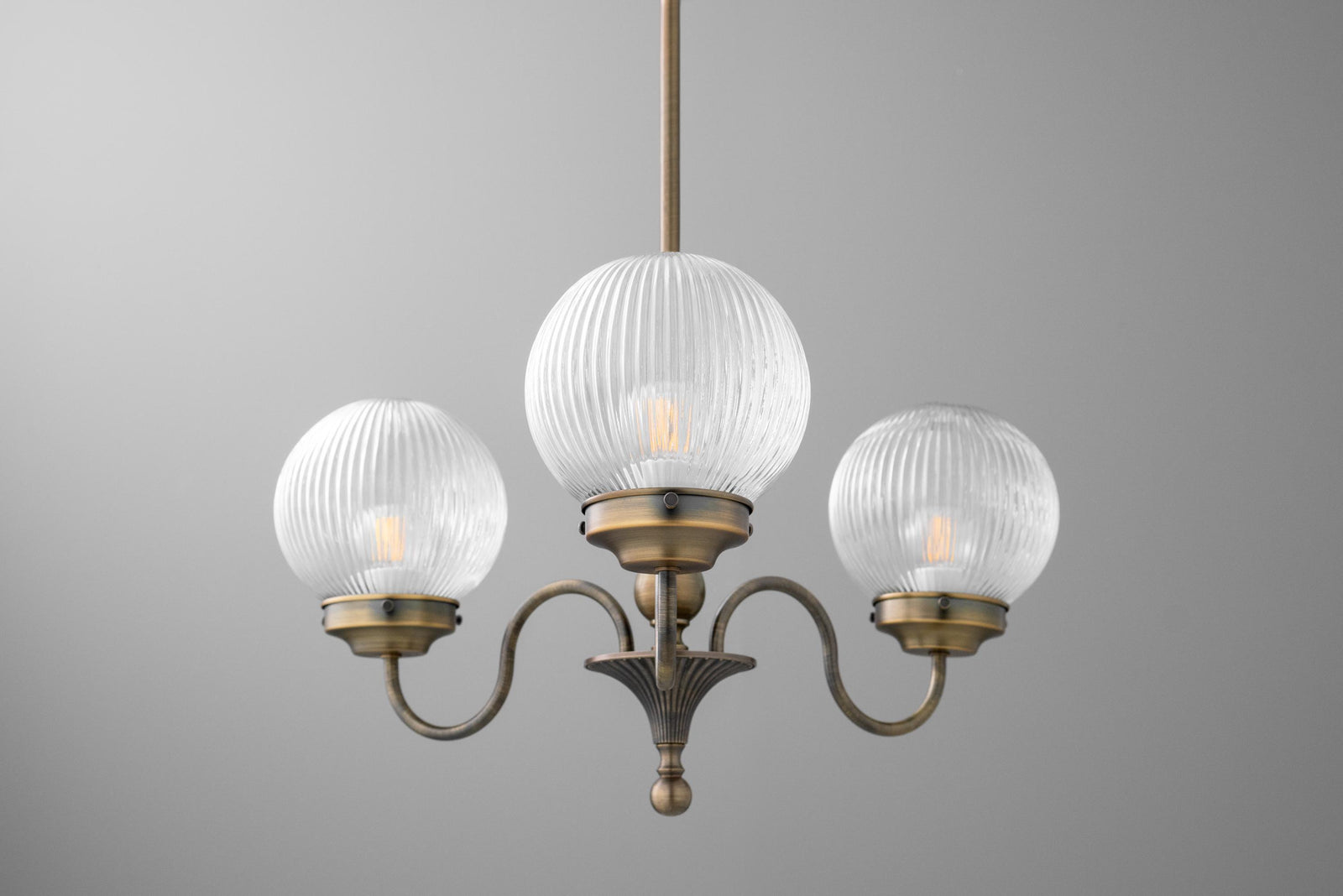 Antique brass chandelier with three ribbed glass globe shades and curved arms. - CHANDELIER MODEL NO. 2894