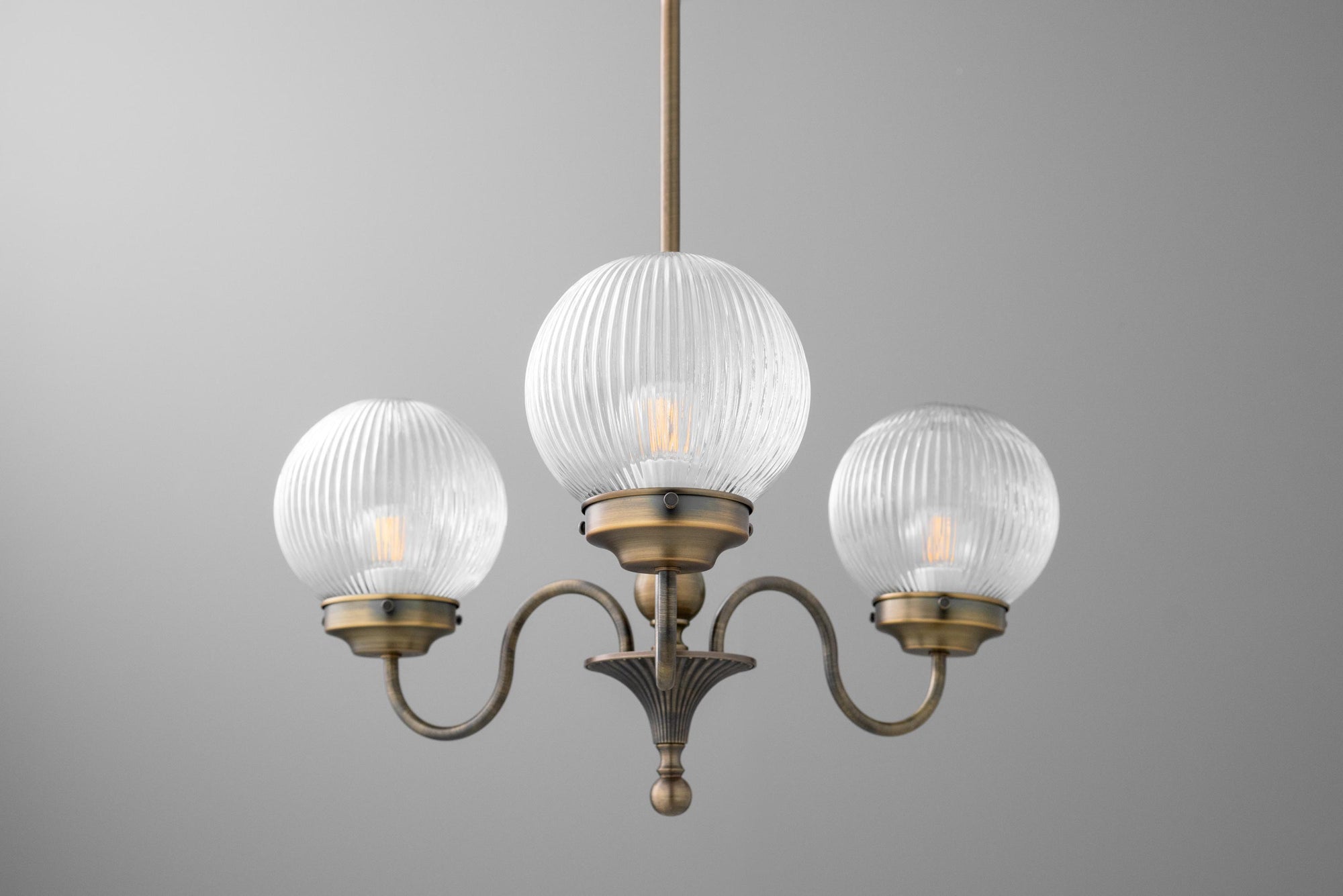 Antique brass chandelier with three ribbed glass globe shades and curved arms. - CHANDELIER MODEL NO. 2894