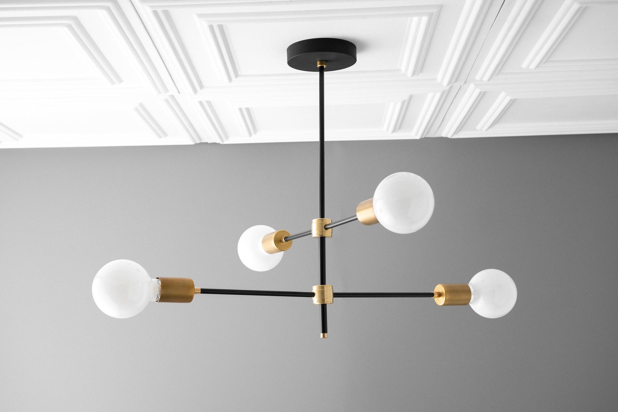 Art Deco chandelier with black metal arms and sealed brass accents holding four white globe bulbs. - CHANDELIER MODEL NO. 5598