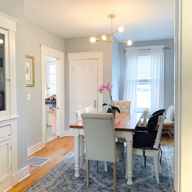 Black and brass Art Deco chandelier with exposed bulbs above wooden dining table. - CHANDELIER MODEL NO. 5598