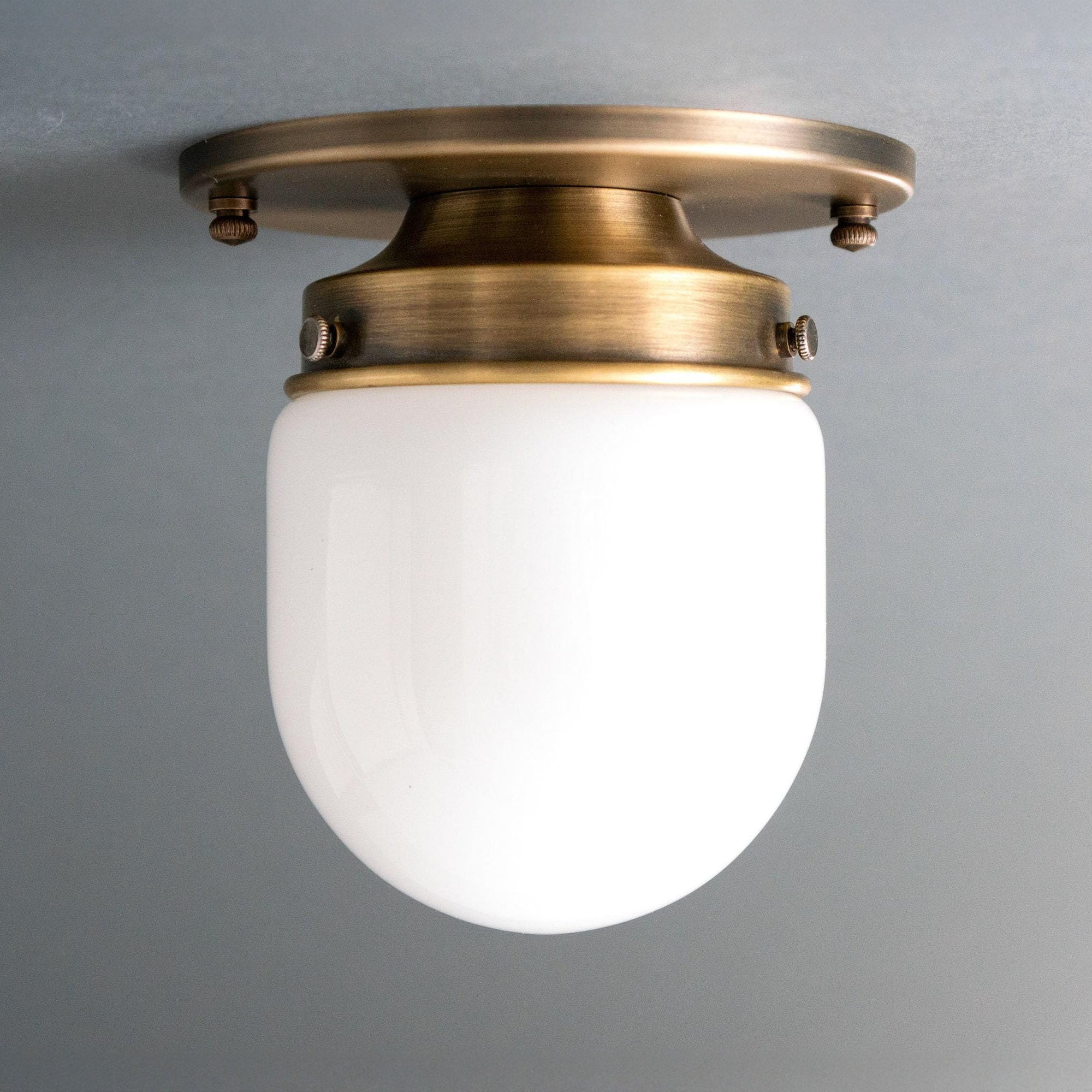 Flush mount ceiling light with an antique brass finish and white glass globe shade. - CEILING LIGHT MODEL NO. 9535