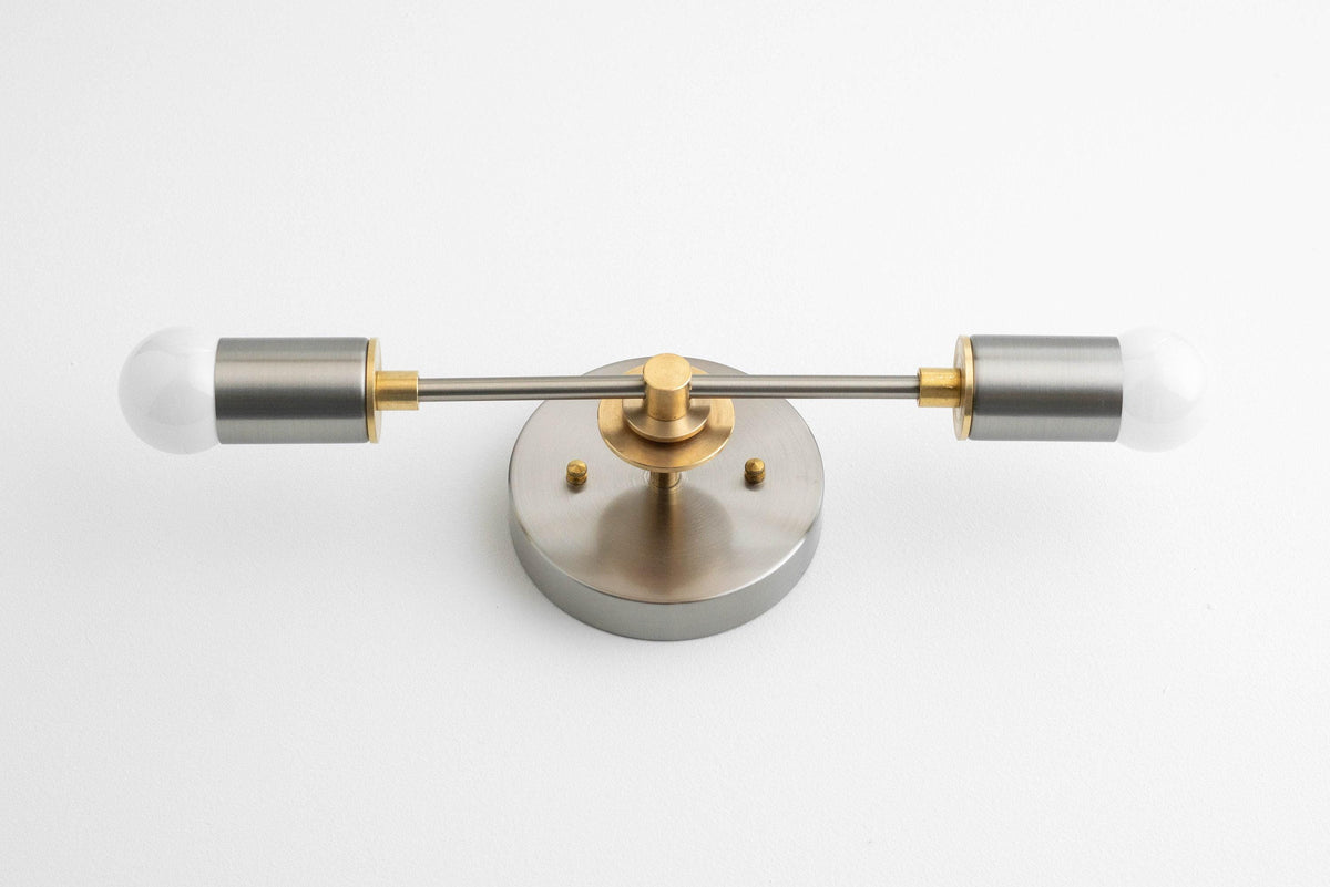 Art Deco vanity light with brushed nickel round base and two raw brass arms holding cylindrical shades. - VANITY LIGHT MODEL NO. 8057