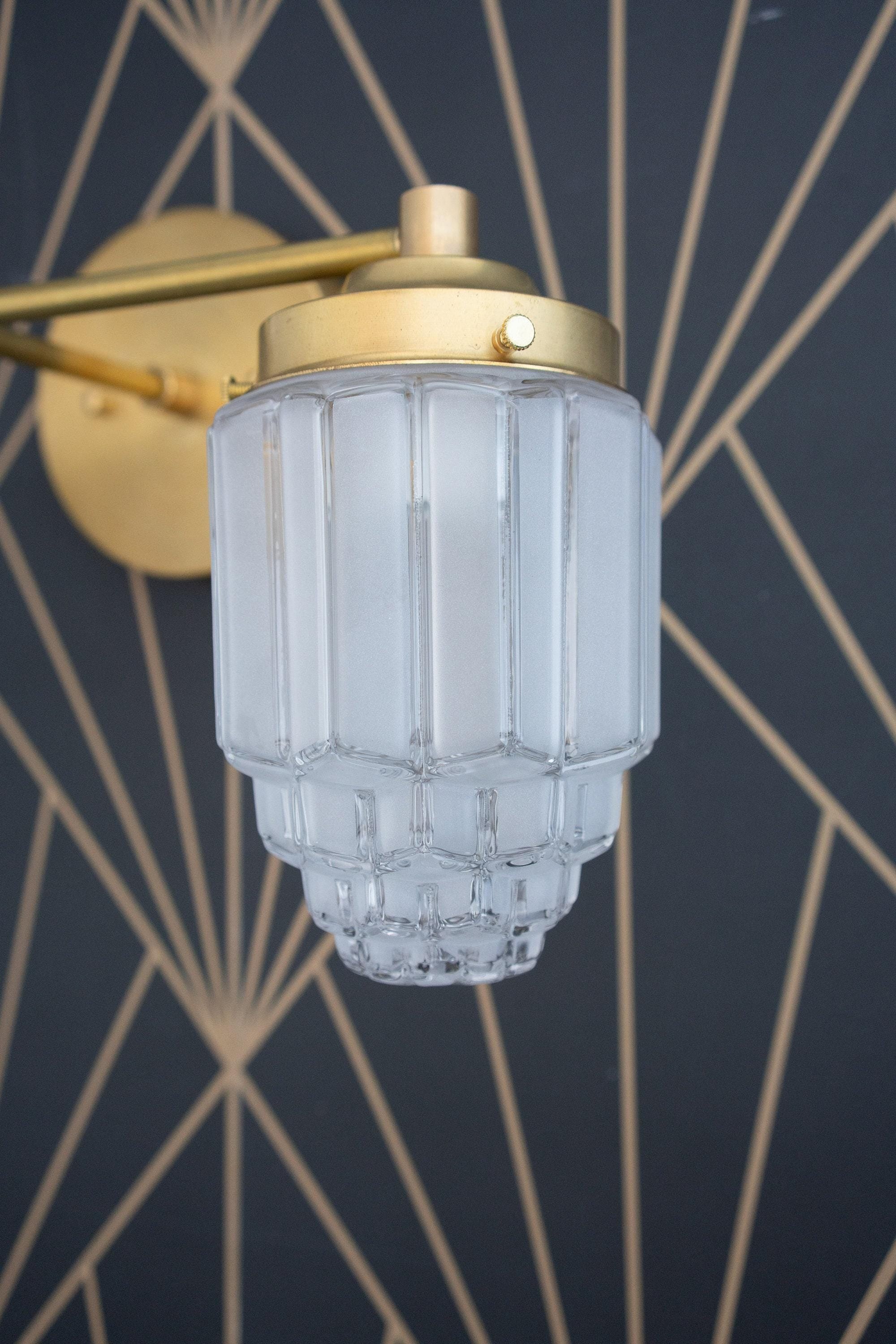 Two-bulb vanity light with raw brass finish and tiered frosted glass globe shade on geometric dark wall. - VANITY LIGHT MODEL NO. 9777