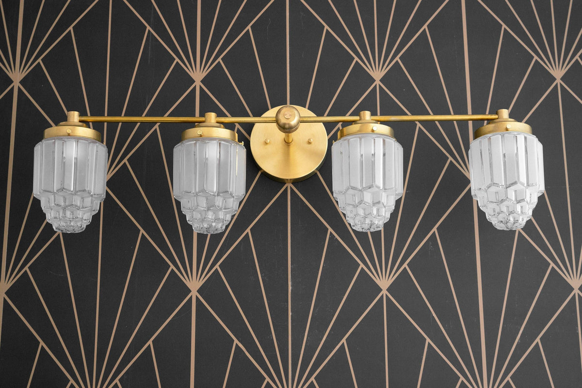Art Deco 4-bulb vanity light with fluted glass globes and antique brass finish mounting plate. - VANITY LIGHT MODEL NO. 1082