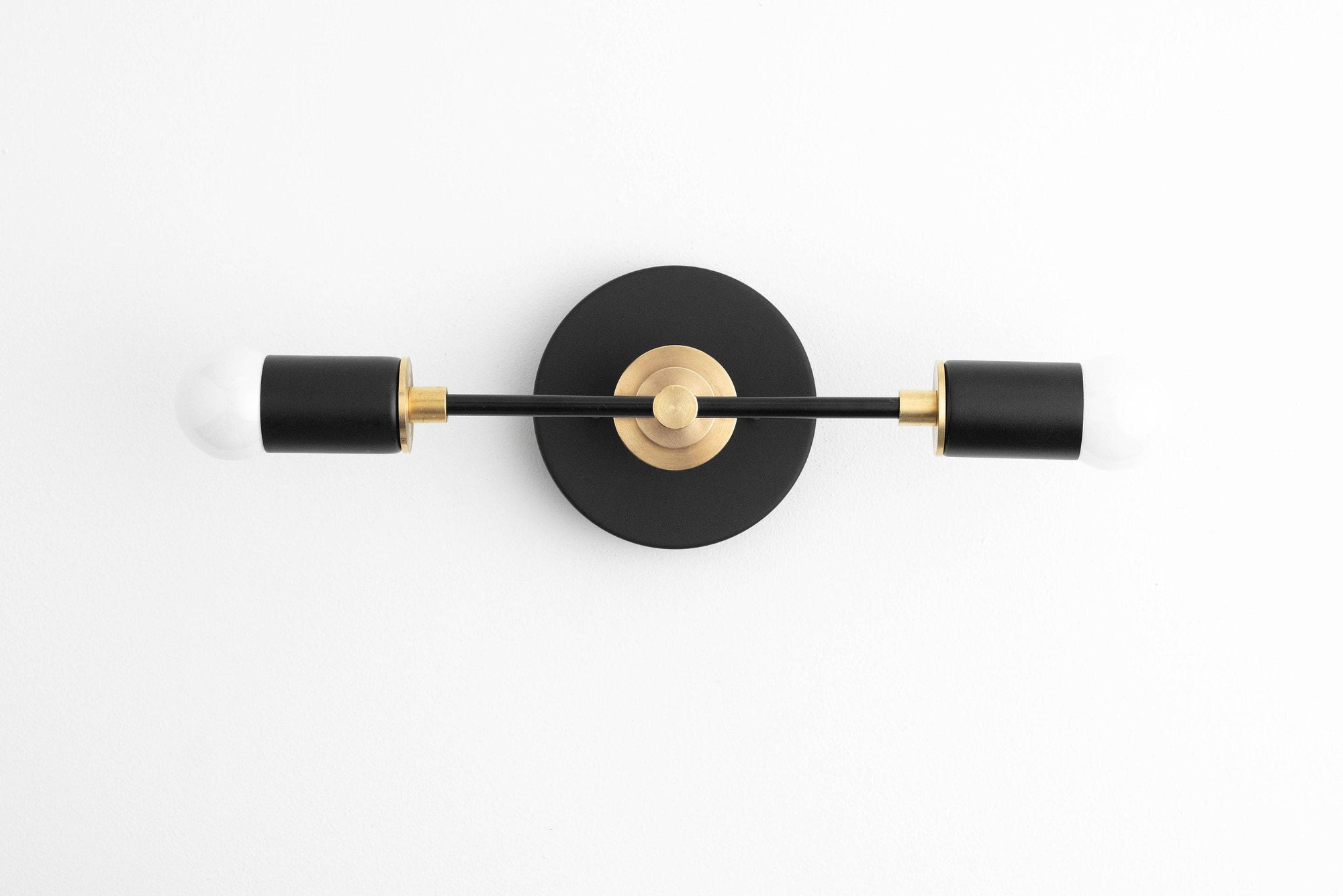 Art Deco vanity light with black cylindrical shades and raw brass center on black round base. - VANITY LIGHT MODEL NO. 8057