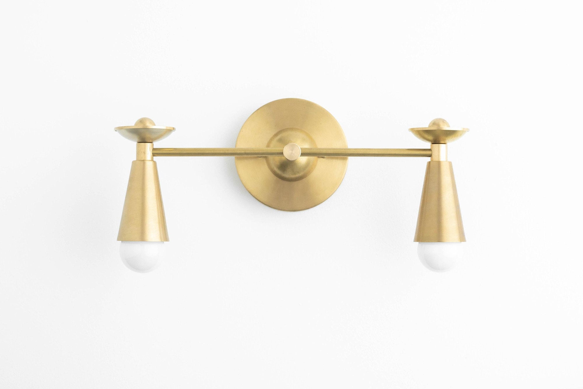 Raw brass Art Deco vanity light with two cone-shaped shades and exposed bulbs. - VANITY LIGHT MODEL NO. 4517