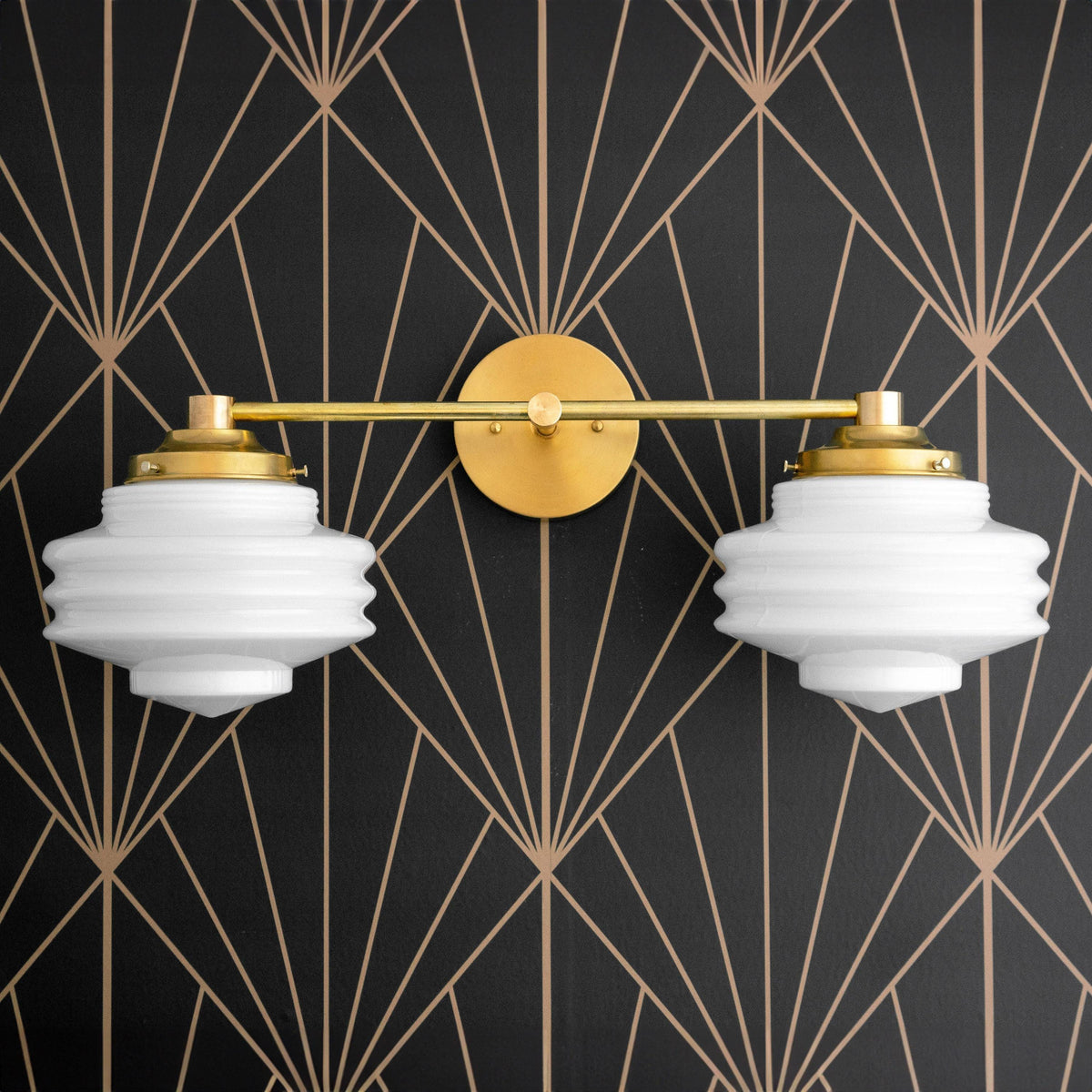Art Deco vanity light with two ribbed white glass globes and raw brass finish mounted on black geometric wallpaper. - VANITY LIGHT MODEL NO. 9479