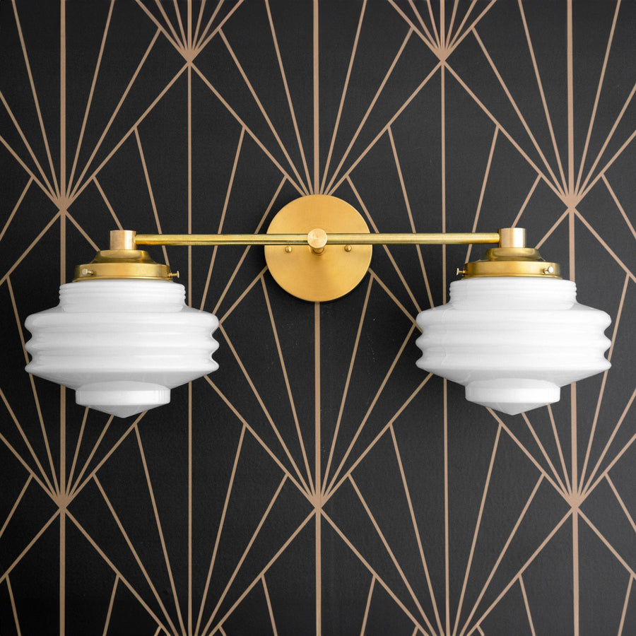 Art Deco vanity light with two ribbed white glass globes and raw brass finish mounted on black geometric wallpaper. - VANITY LIGHT MODEL NO. 9479