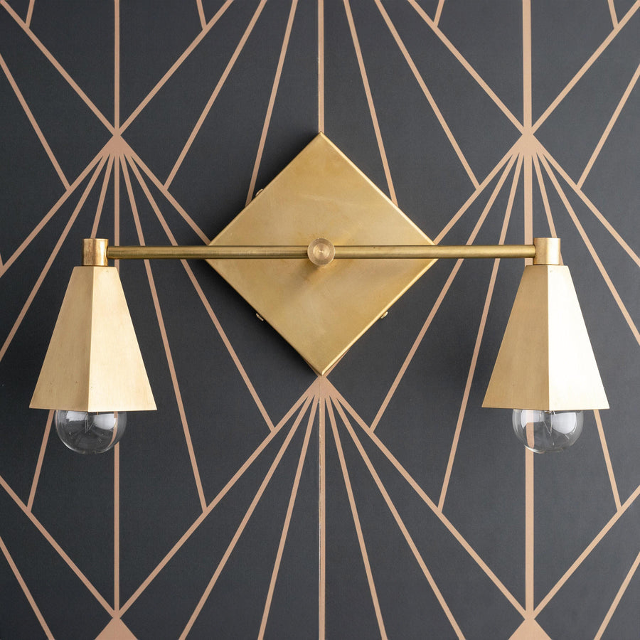 Two-bulb vanity light with raw brass finish and conical shades on geometric dark wall background. - VANITY LIGHT MODEL NO. 4237