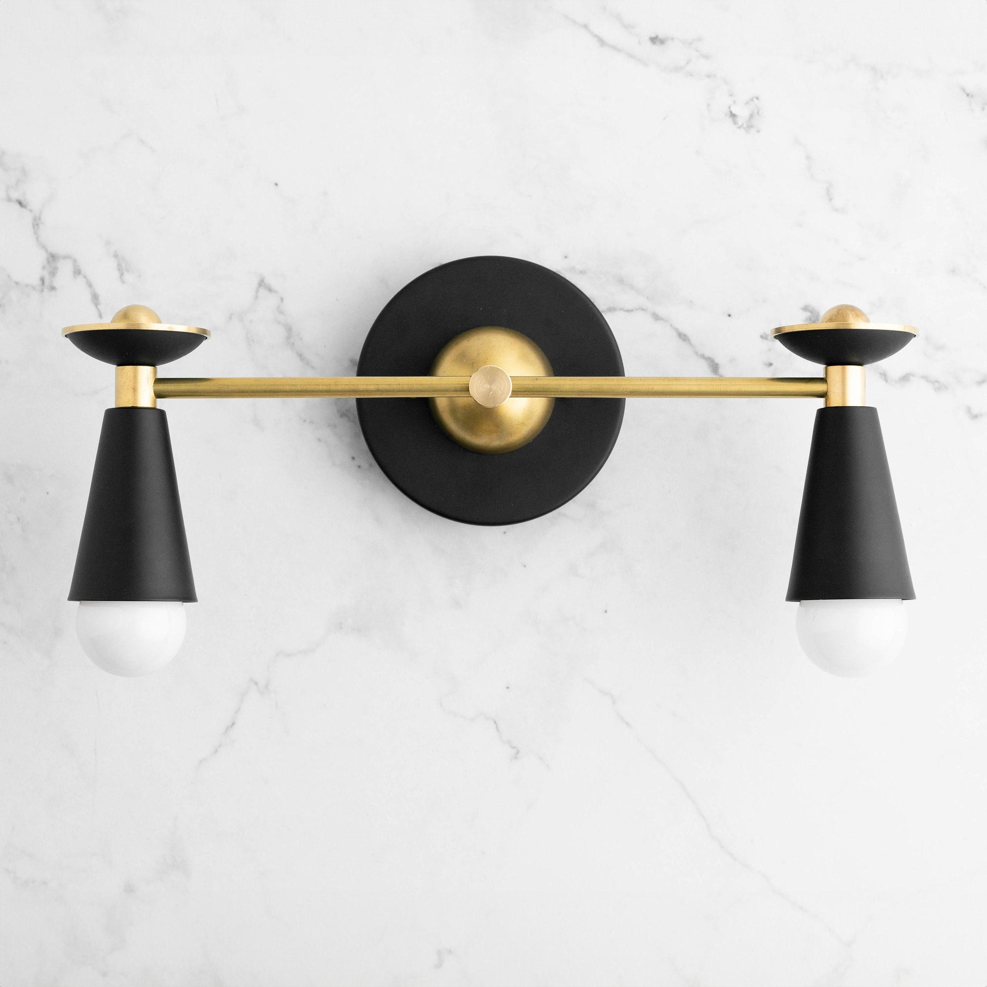 Art Deco style vanity light with black conical shades and raw brass horizontal bar and round wall mount. - VANITY LIGHT MODEL NO. 4517