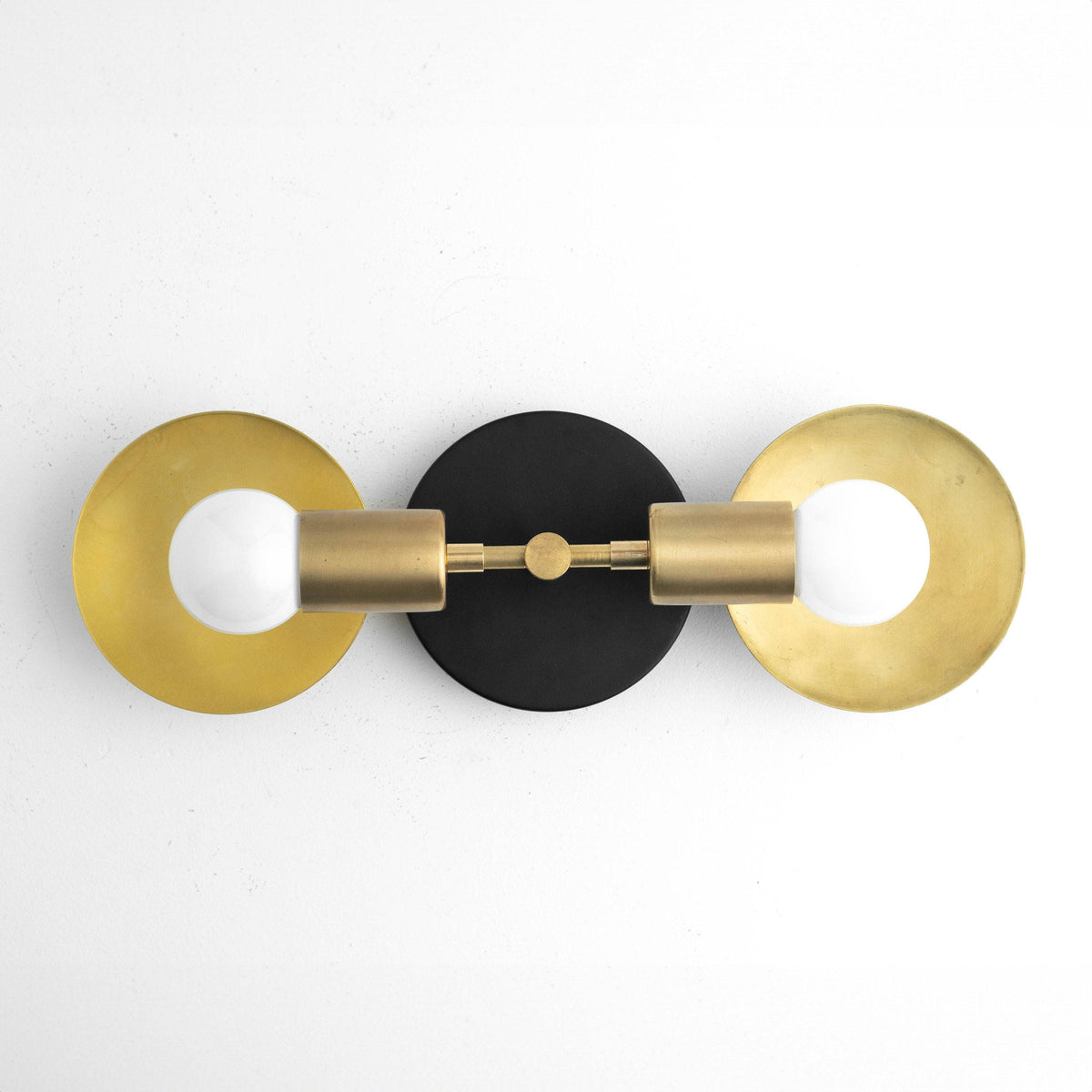 Art Deco 2-bulb vanity light with raw brass cylindrical sockets and circular brass backplates on black mounting plate. - VANITY LIGHT MODEL NO. 2945