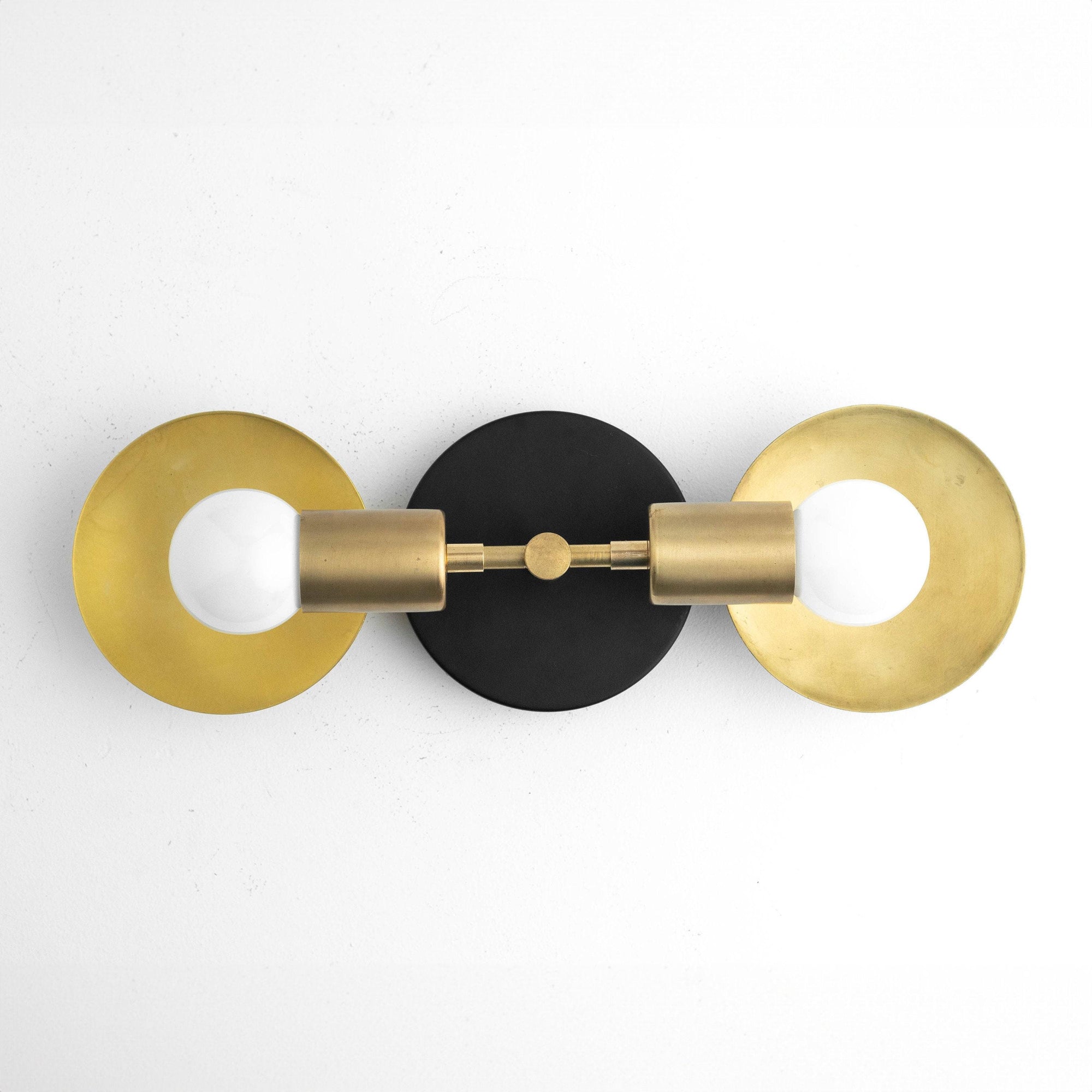 Art Deco 2-bulb vanity light with raw brass cylindrical sockets and circular brass backplates on black mounting plate. - VANITY LIGHT MODEL NO. 2945