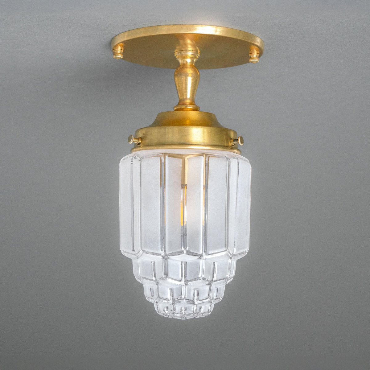 Semi-flush ceiling light with a brass canopy and turned stem holding a stepped Art Deco shade. - CEILING LIGHT MODEL NO. 7466