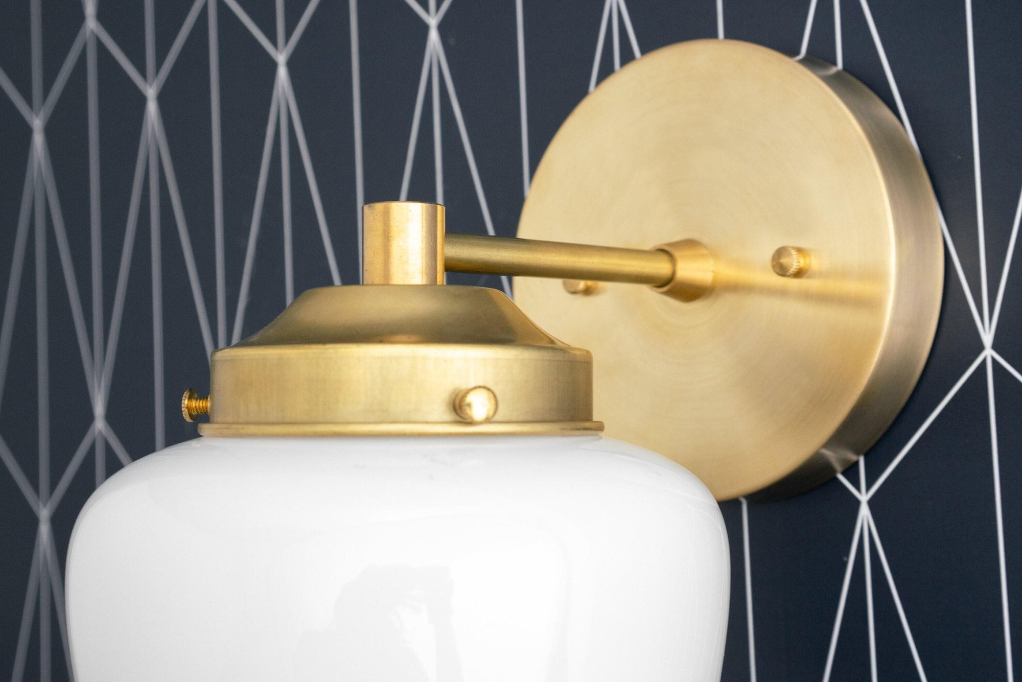 Art Deco wall sconce with raw brass finish and white globe shade mounted on round backplate. - SCONCE MODEL NO. 7321