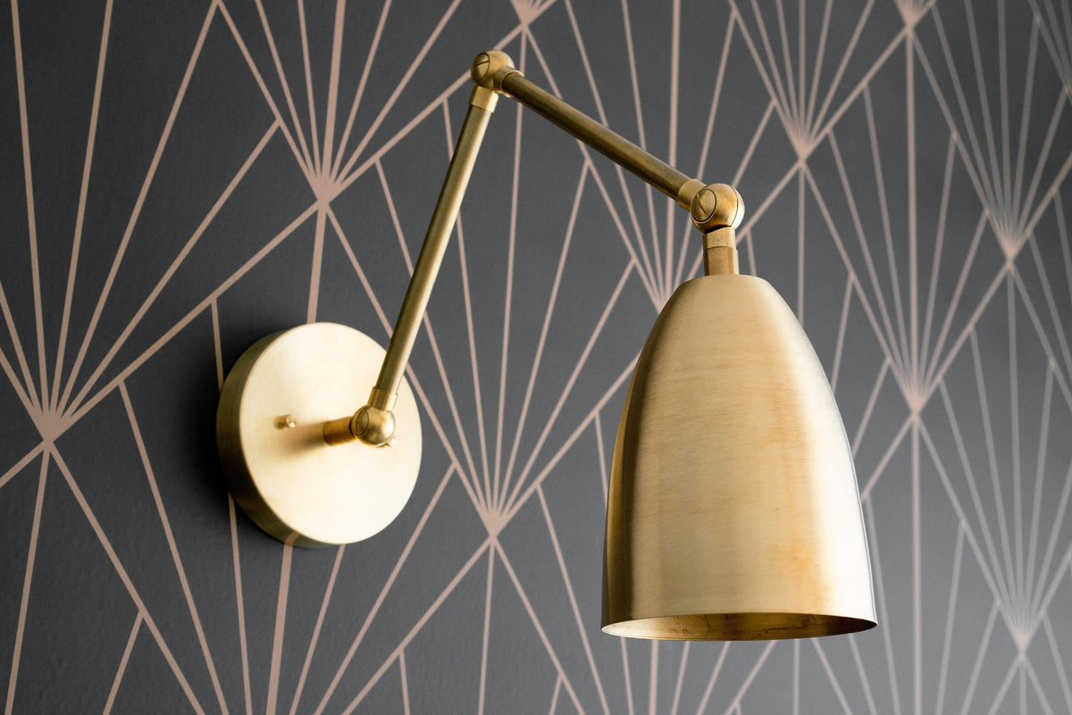 Adjustable raw brass Art Deco wall sconce with conical shade and swivel arm on geometric wallpaper background. - SCONCE MODEL NO. 0107