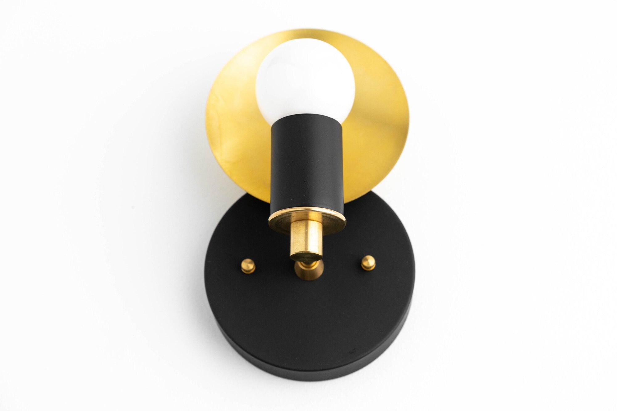 Art Deco black wall sconce with brass circular backplate and exposed bulb. - SCONCE MODEL NO. 8677