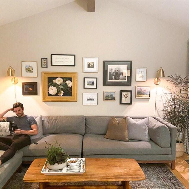 Raw brass adjustable Art Deco wall sconces with conical shades above gray sectional sofa in modern living room. - SCONCE MODEL NO. 0107