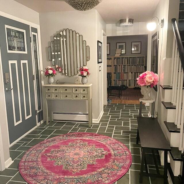 Art Deco semi-flush globe sconce with black and brass finish, mounted in an entryway with gray doors and pink floral accents. - SCONCE MODEL NO. 1045