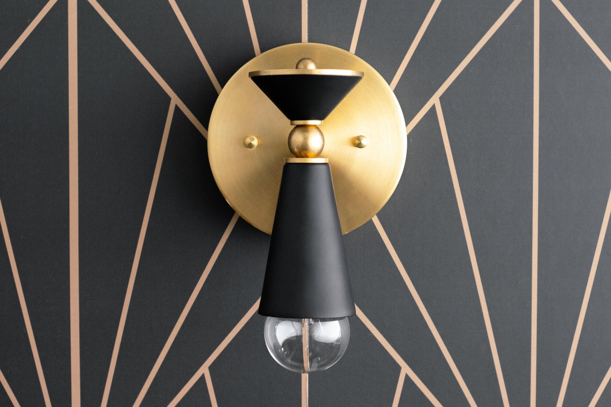 Art Deco brass and black wall sconce with exposed bulb and geometric backplate design. - SCONCE MODEL NO. 8393