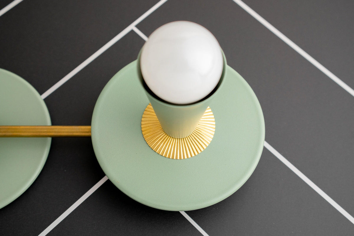 Raw brass vanity light with green circular base, fluted gold accent, and white globe bulb. - VANITY LIGHT MODEL NO. 4473