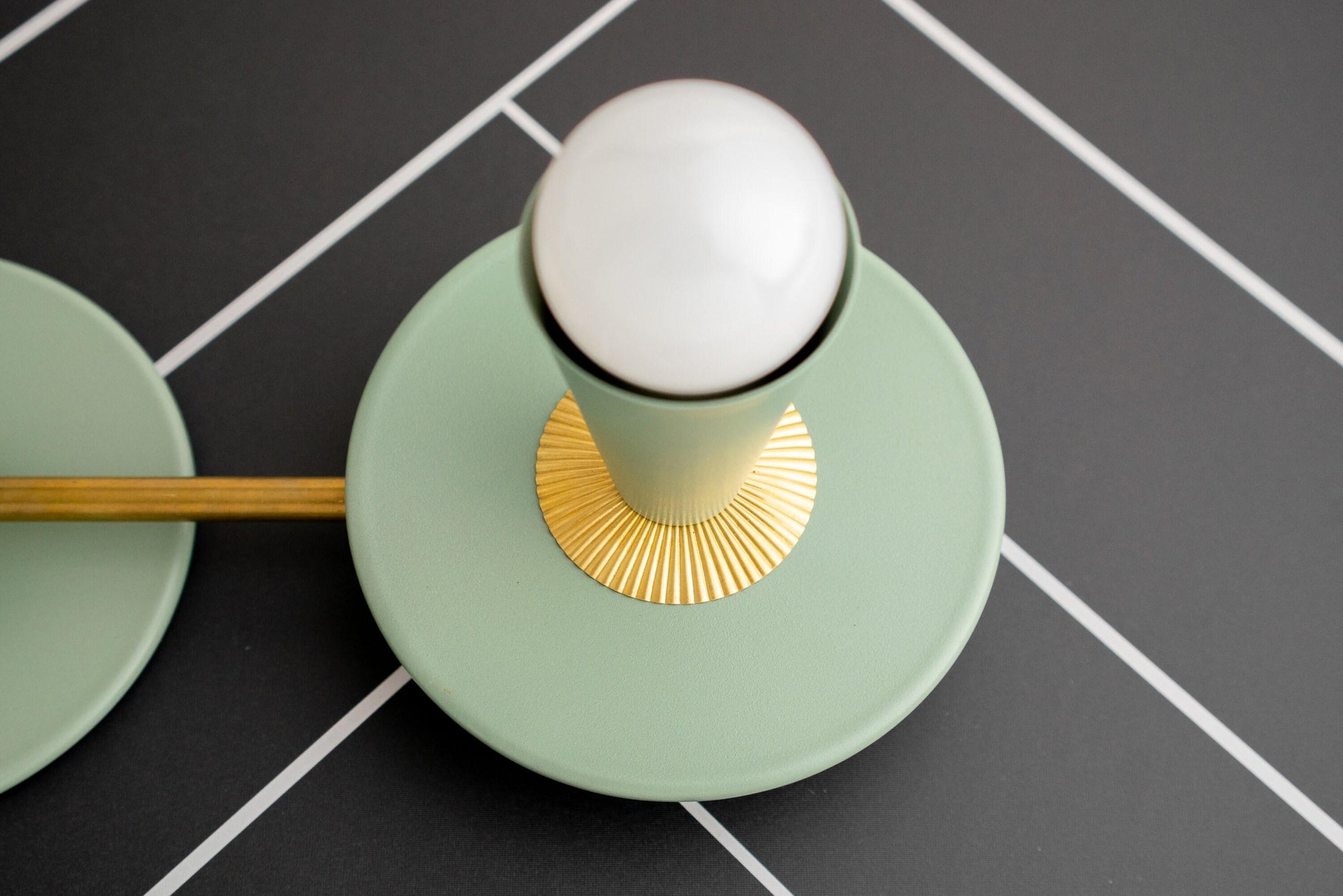 Raw brass vanity light with green circular base, fluted gold accent, and white globe bulb. - VANITY LIGHT MODEL NO. 4473