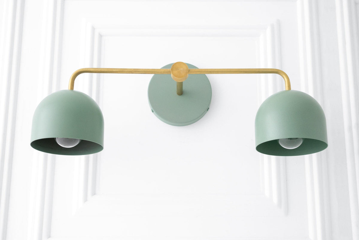 Art Deco two-bulb vanity light with raw brass arm and coal blue metal shades mounted on white wall. - VANITY LIGHT MODEL NO. 2082