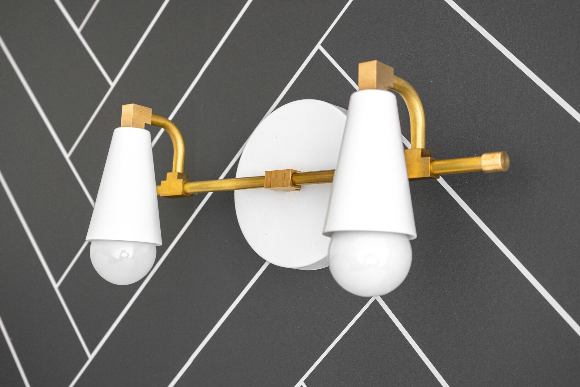 Raw brass vanity light with two white tapered cone shades and exposed bulbs on round backplate. - VANITY LIGHT MODEL NO. 1229