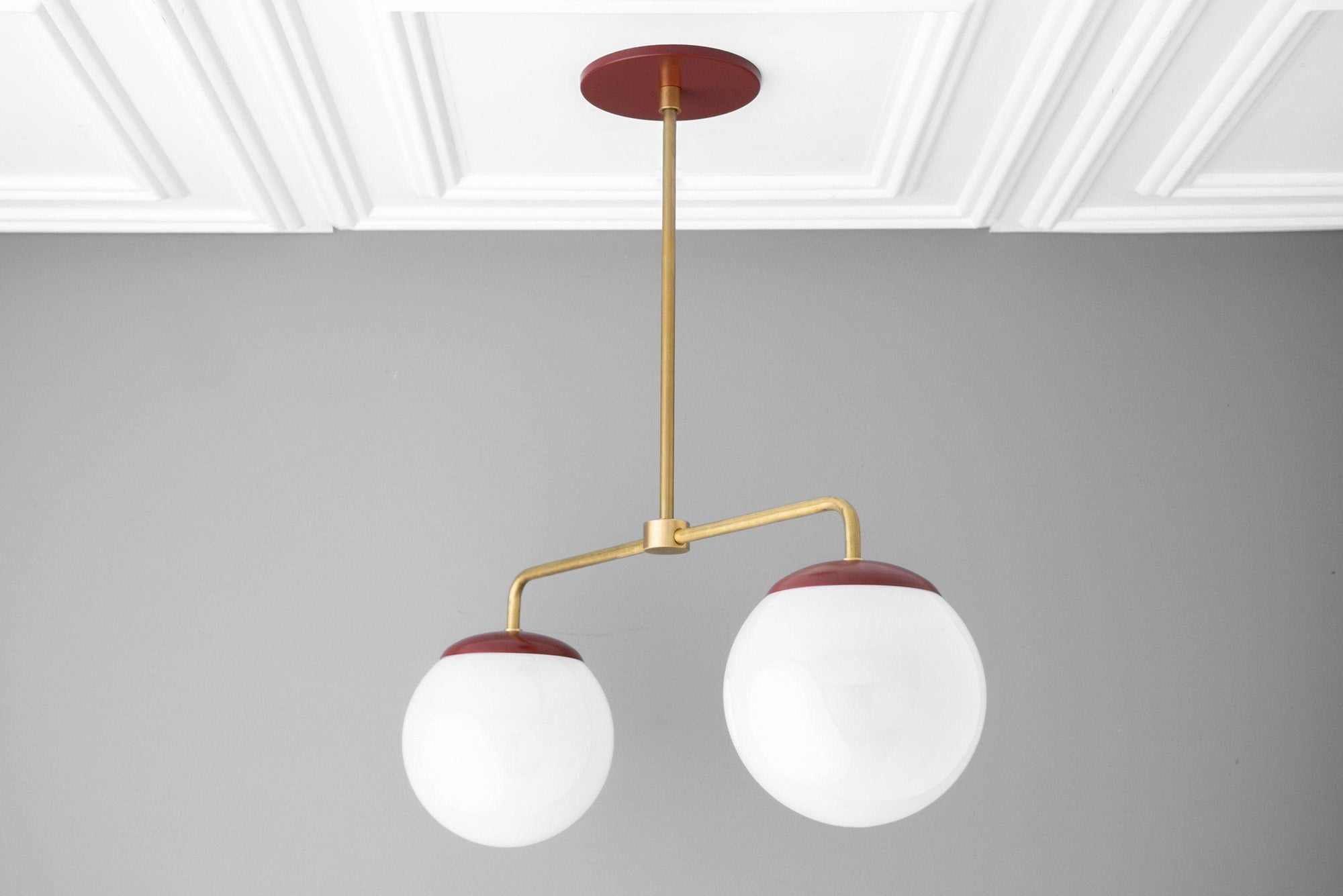 Mid-century modern chandelier with two white glass globes and raw brass arms with red accents. - CHANDELIER MODEL NO. 3883