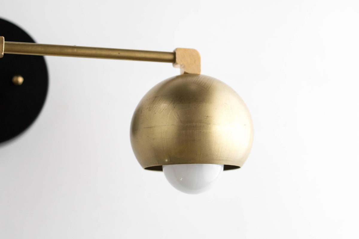 Mid-century modern brass vanity light with exposed white bulb and black wall mount. - VANITY LIGHT MODEL NO. 5469