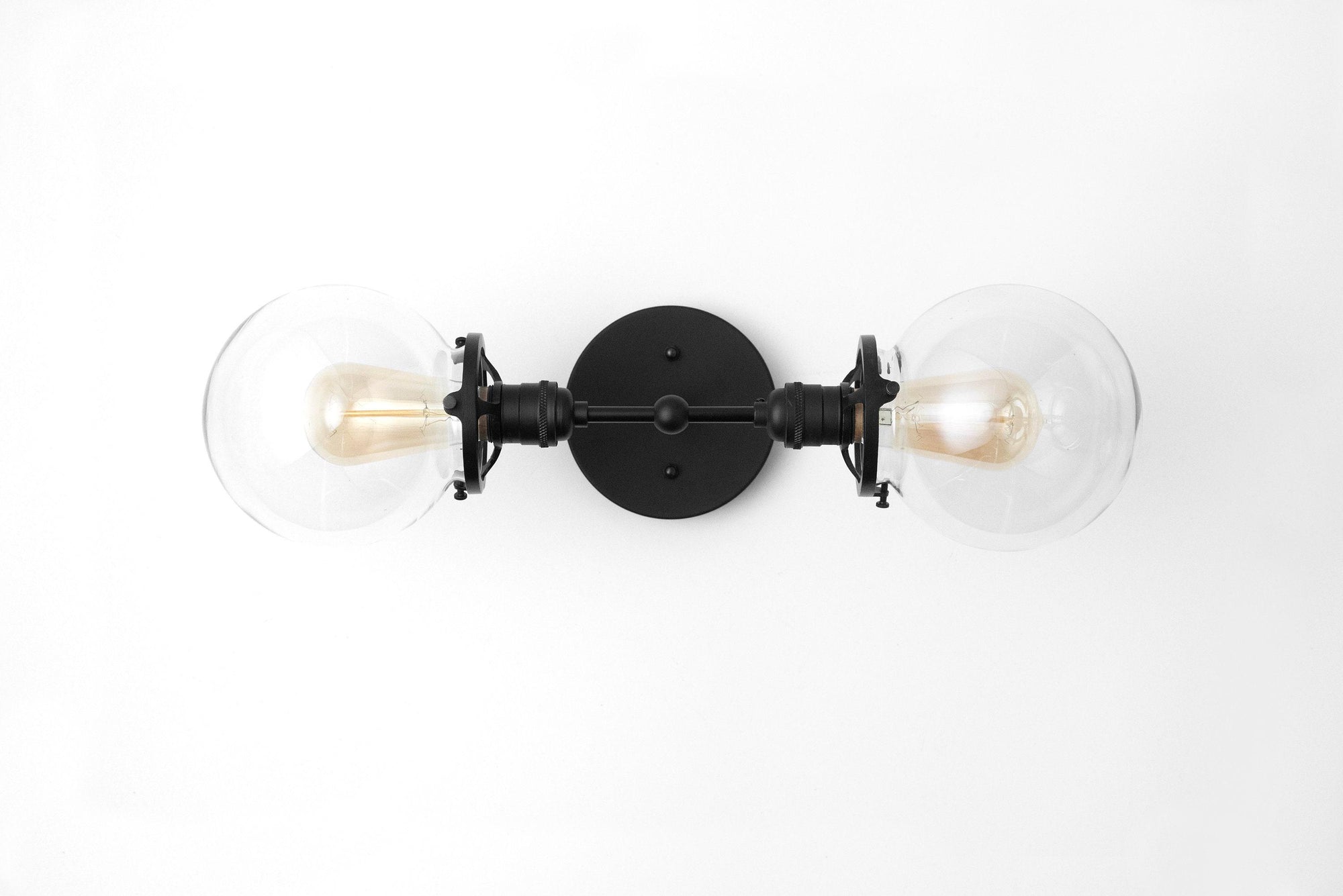 Black two-bulb vanity light with clear globe shades and round mounting plate. - VANITY LIGHT MODEL NO. 7350