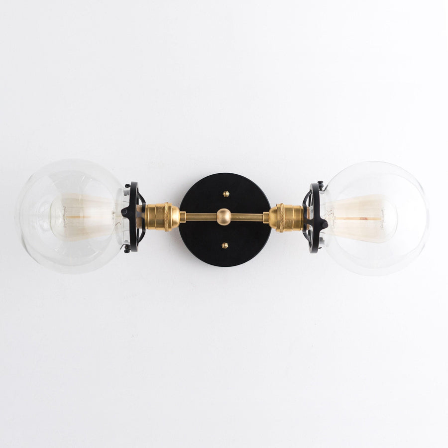 Art Deco vanity light with two clear glass globes and black and brass metal accents. - VANITY LIGHT MODEL NO. 7350
