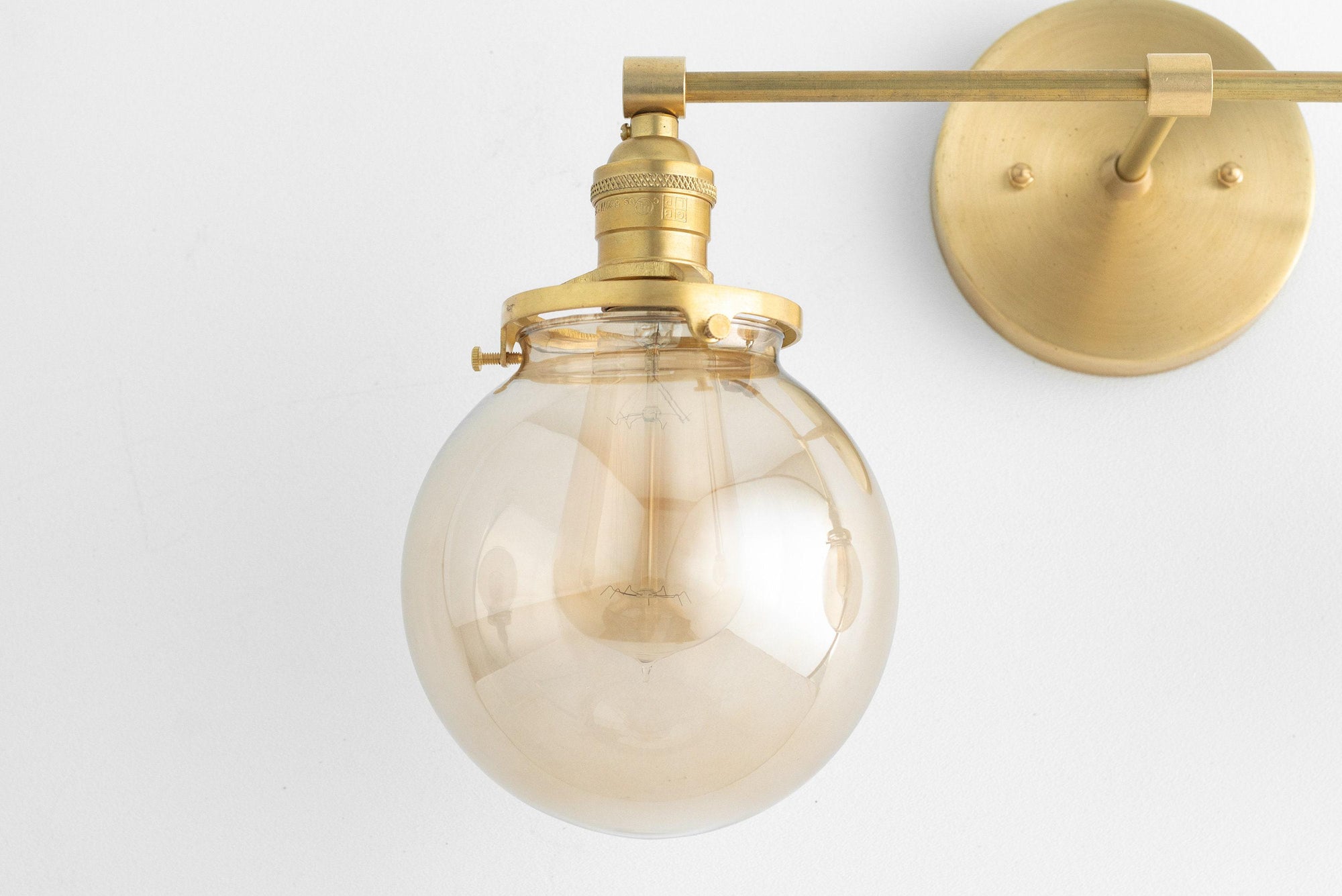 Mid-century modern vanity light with raw brass finish and clear globe shade. - VANITY LIGHT MODEL NO. 4270