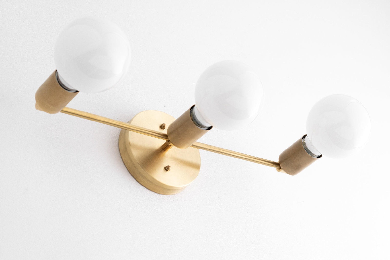 Mid-century modern 3-bulb vanity light with raw brass finish and round white bulbs. - VANITY LIGHT MODEL NO. 0518