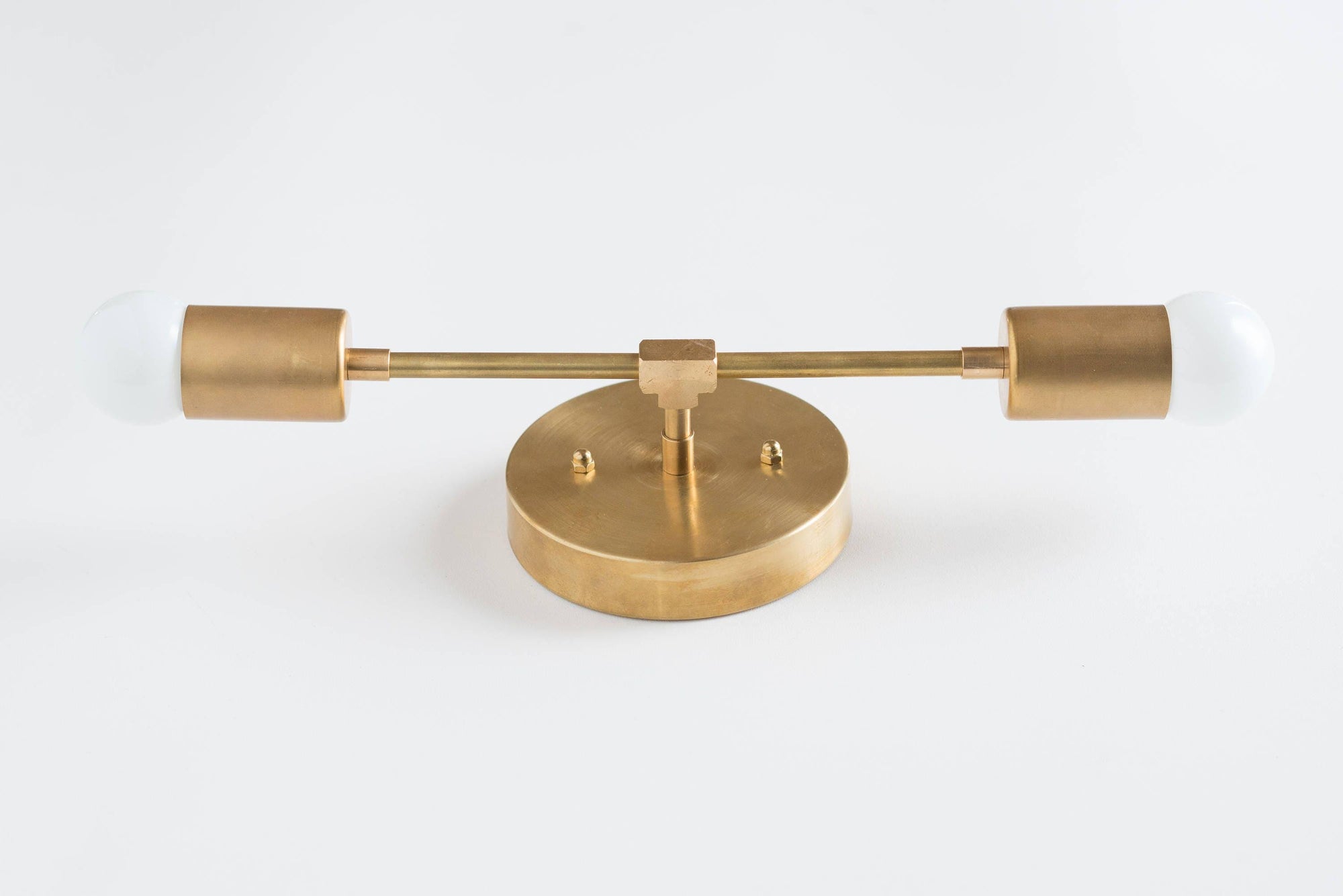 Mid-century modern brass vanity light with two exposed bulbs and round wall mount. - VANITY LIGHT MODEL NO. 5563