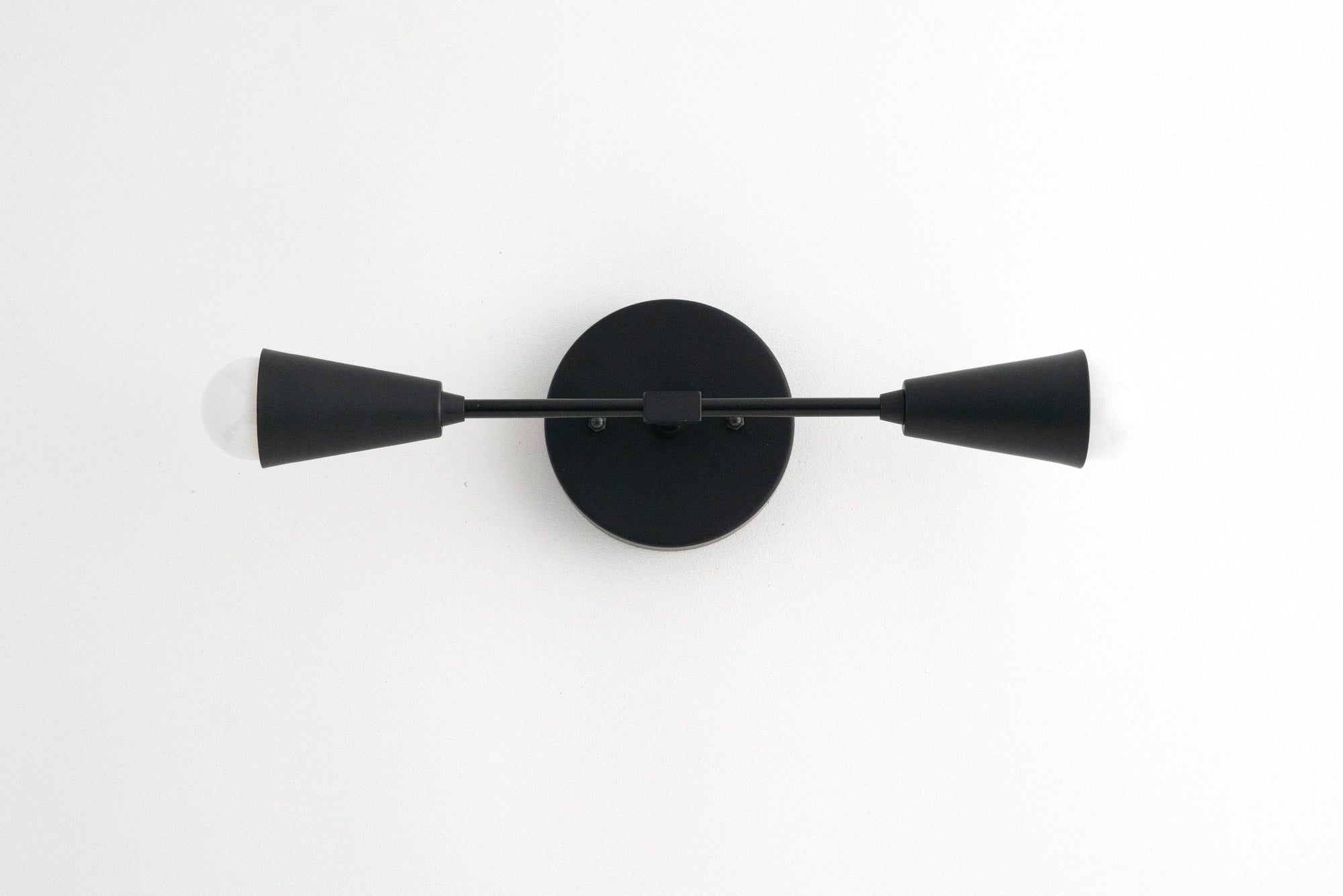 Mid-century modern black metal vanity light with two cone-shaped shades and round wall mount. - VANITY LIGHT MODEL NO. 3209