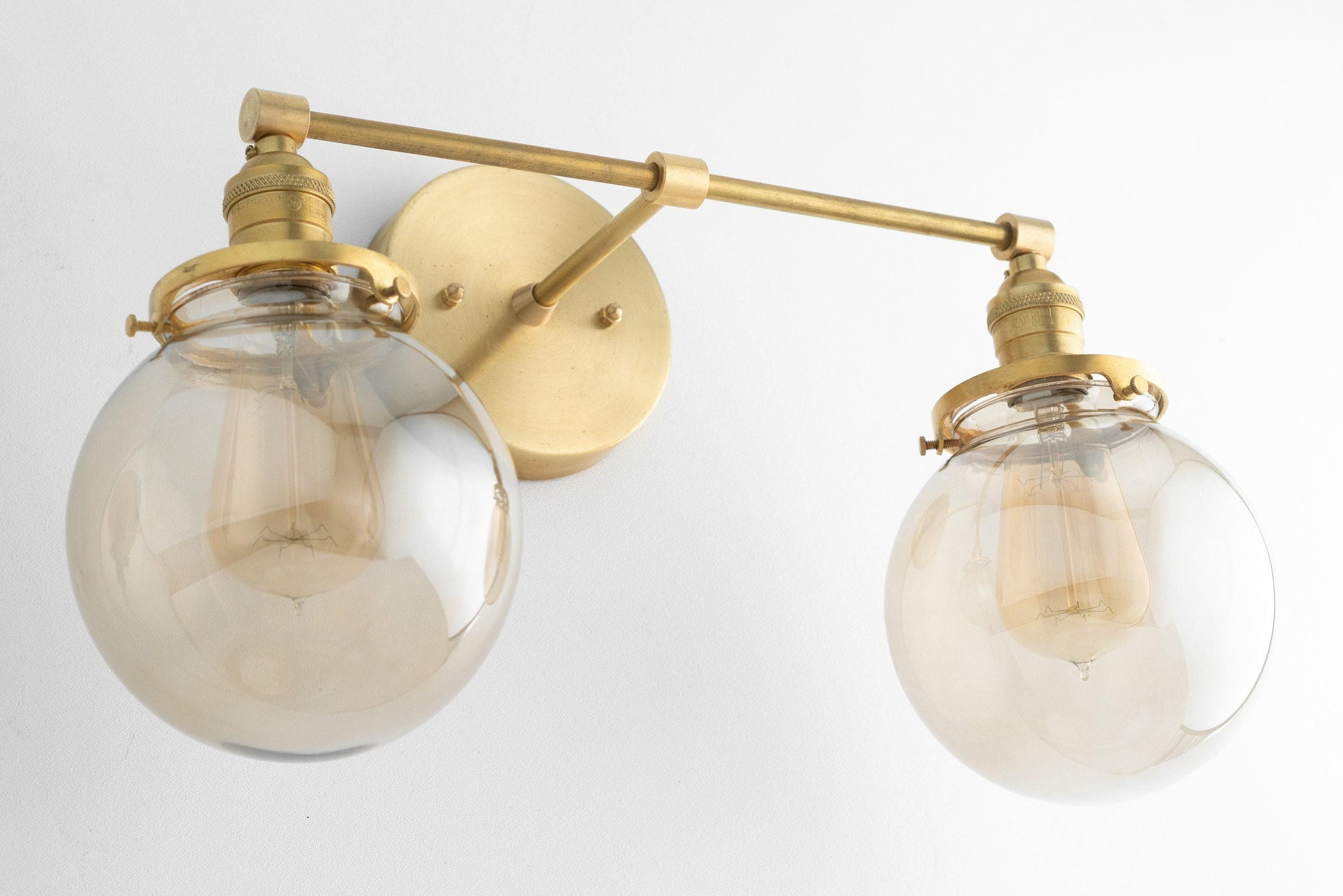 Mid-century modern two-bulb vanity light with raw brass finish and clear glass globe shades. - VANITY LIGHT MODEL NO. 4270