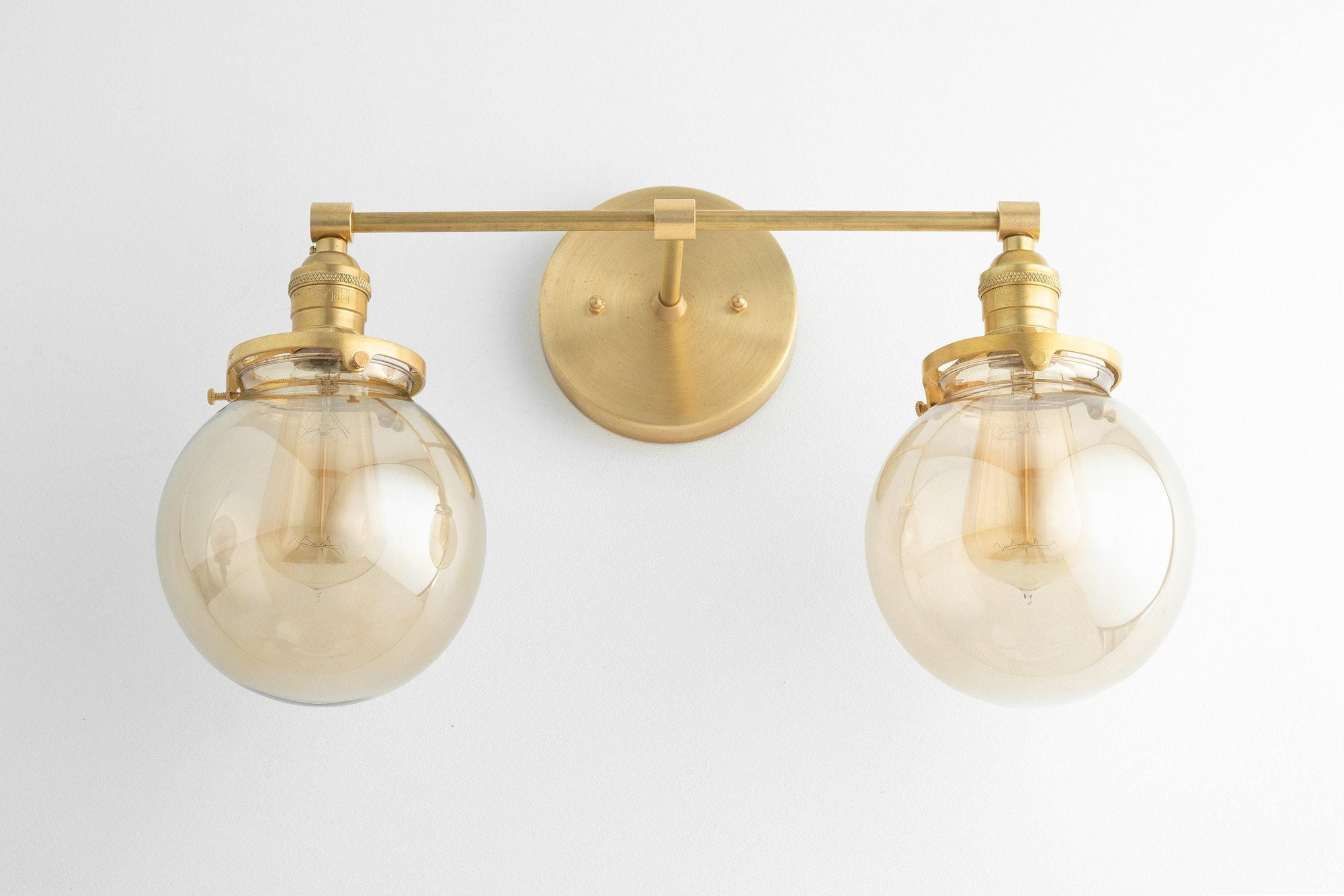 Mid-century modern two-bulb vanity light with raw brass finish and clear globe shades. - VANITY LIGHT MODEL NO. 4270