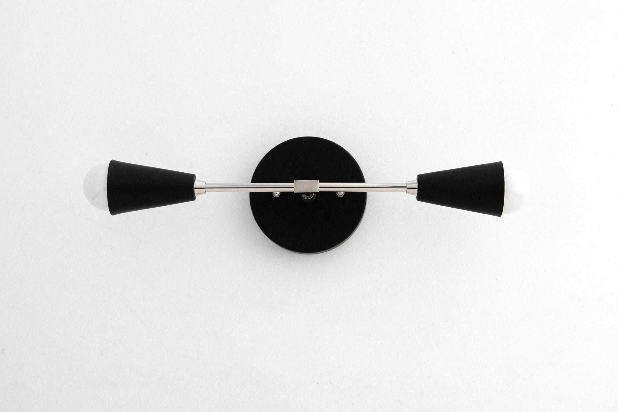Mid-century modern black wall vanity light with two cone-shaped shades and a round backplate. - VANITY LIGHT MODEL NO. 3209