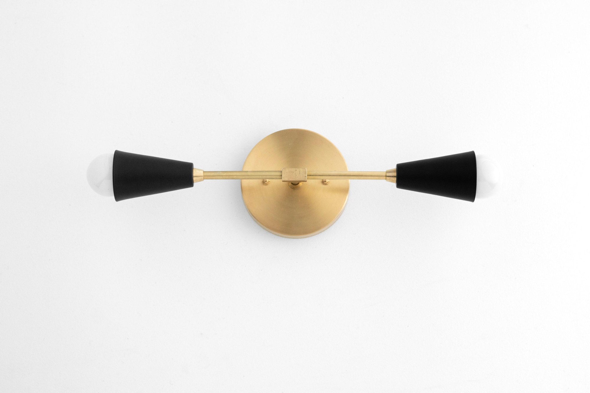 Mid-century vanity light with raw brass round base and two black tapered cone shades. - VANITY LIGHT MODEL NO. 3209