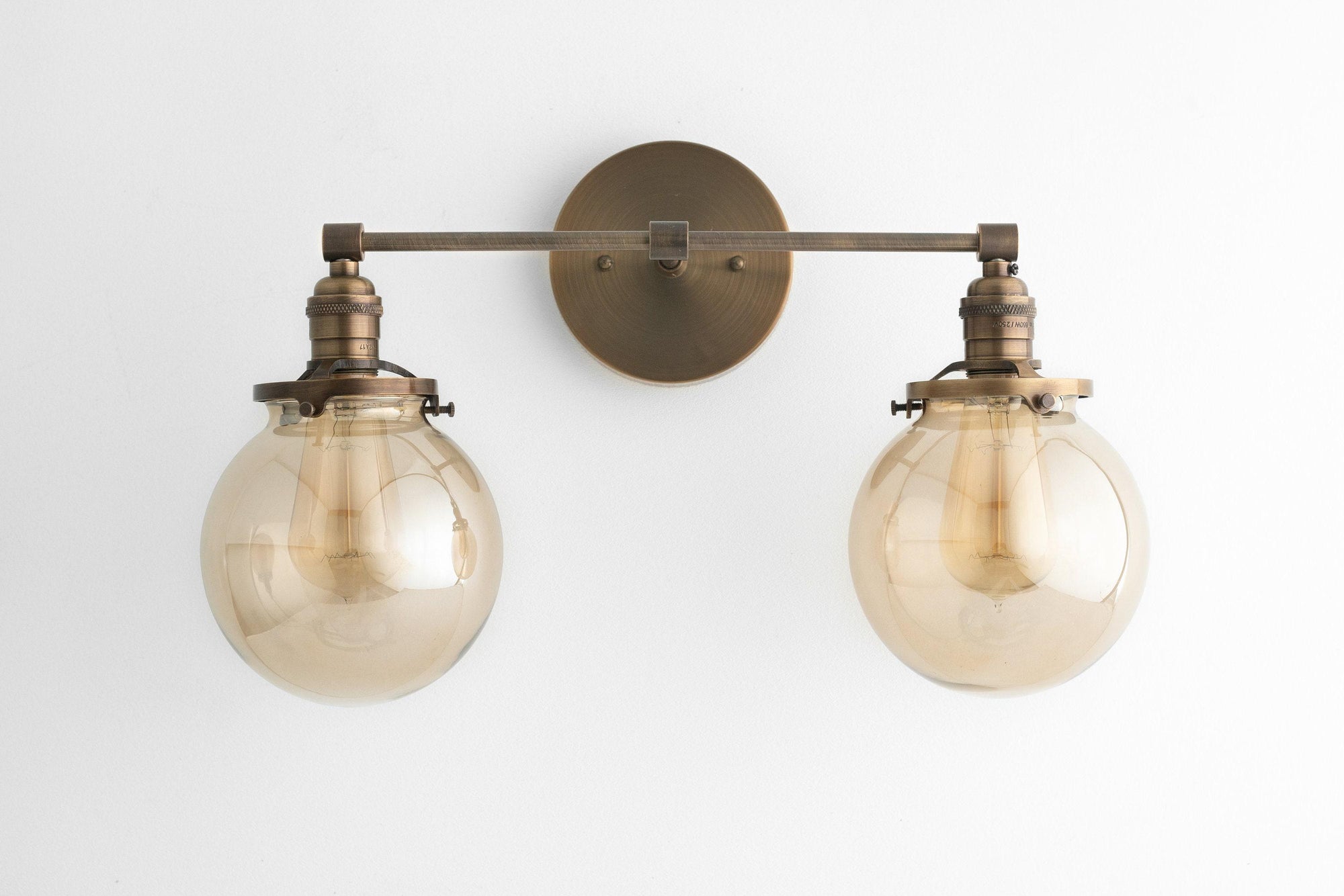 Mid-century modern two-bulb vanity light with raw brass finish and round globe shades. - VANITY LIGHT MODEL NO. 4270