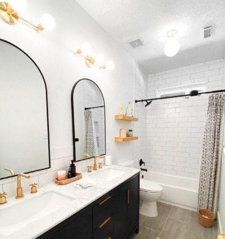 Mid-century modern 3-bulb vanity light in raw brass above dual arched mirrors and black vanity cabinet. - VANITY LIGHT MODEL NO. 0518