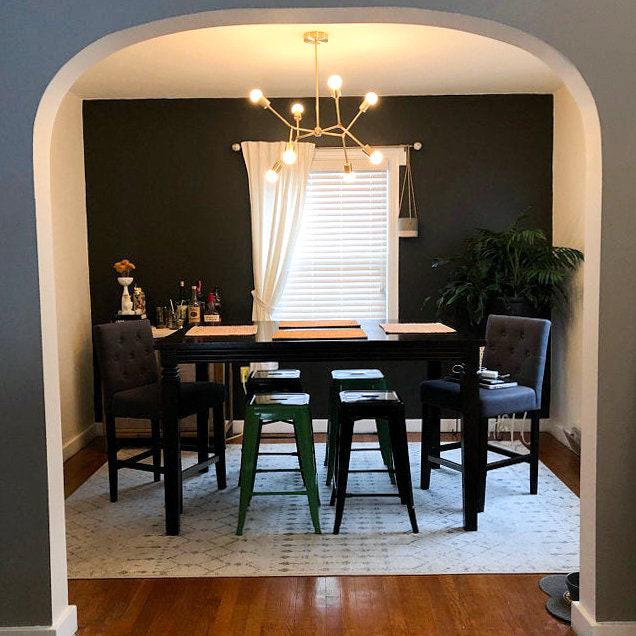 Mid-century modern raw brass chandelier with exposed bulbs hanging above black dining table with textured chairs and metal. - CHANDELIER MODEL NO. 5056
