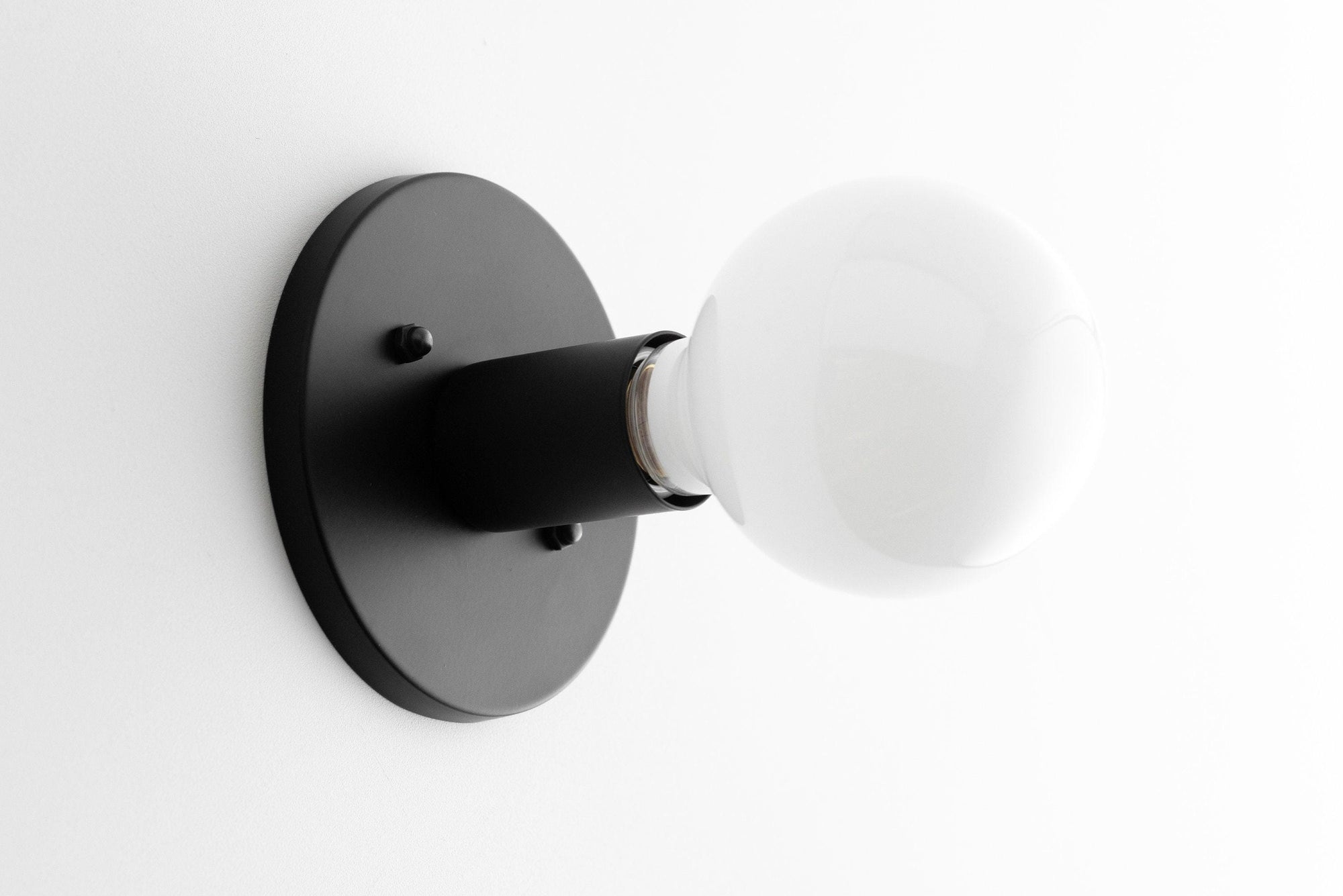 Mid-century modern black flush mount sconce with exposed round white bulb. - SCONCE MODEL NO. 2057
