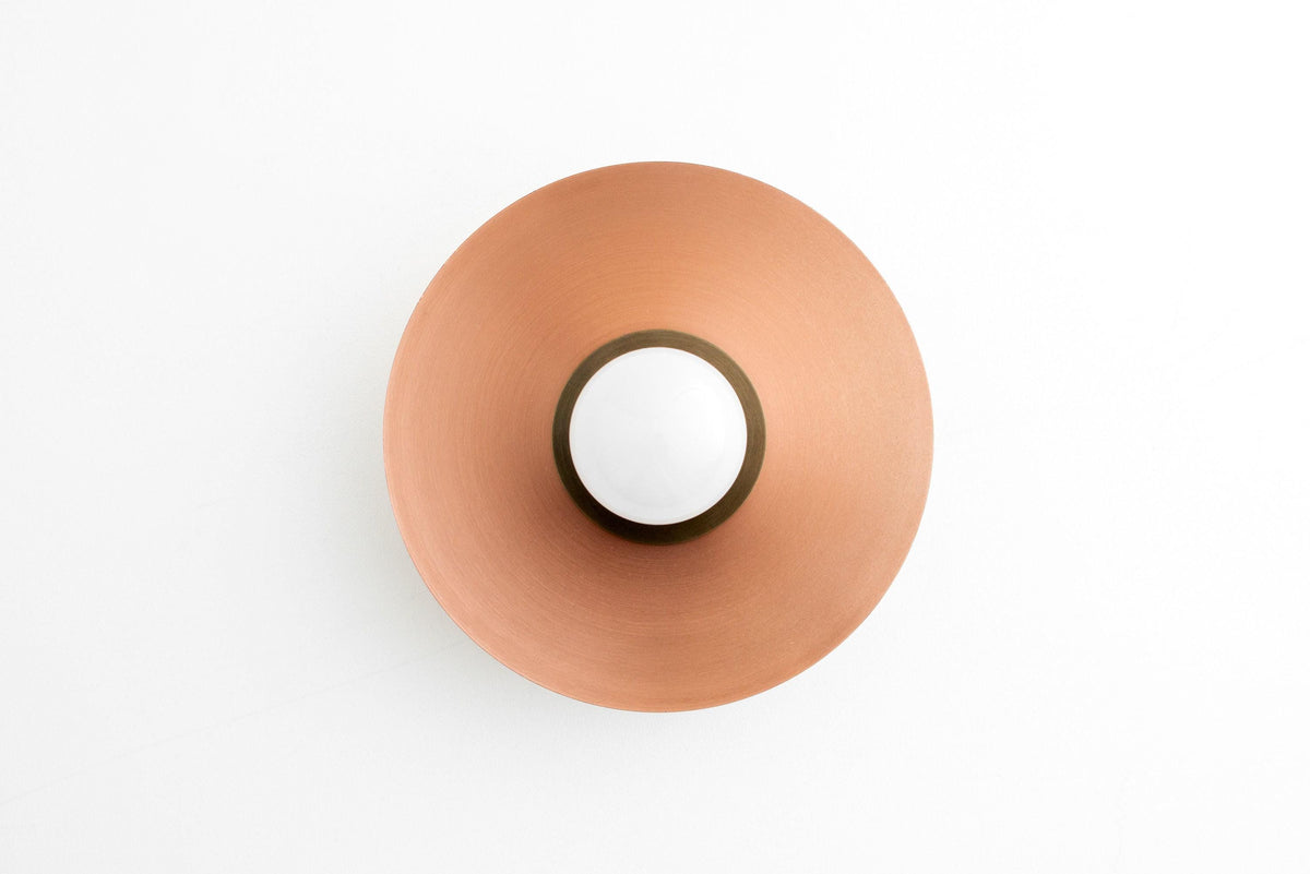 Round flush mount sconce with circular copper-colored metal shade and exposed bulb center. - SCONCE MODEL NO. 7004