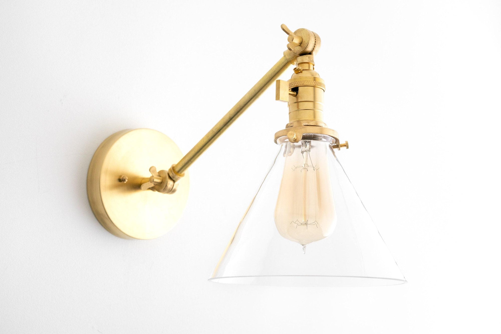 Mid-century modern adjustable wall sconce in raw brass with clear cone glass shade and exposed bulb. - SCONCE MODEL NO. 7962