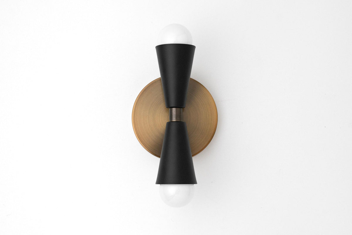 Mid-century modern black double-cone sconce with bare bulbs mounted on round brass base. - SCONCE MODEL NO. 4717