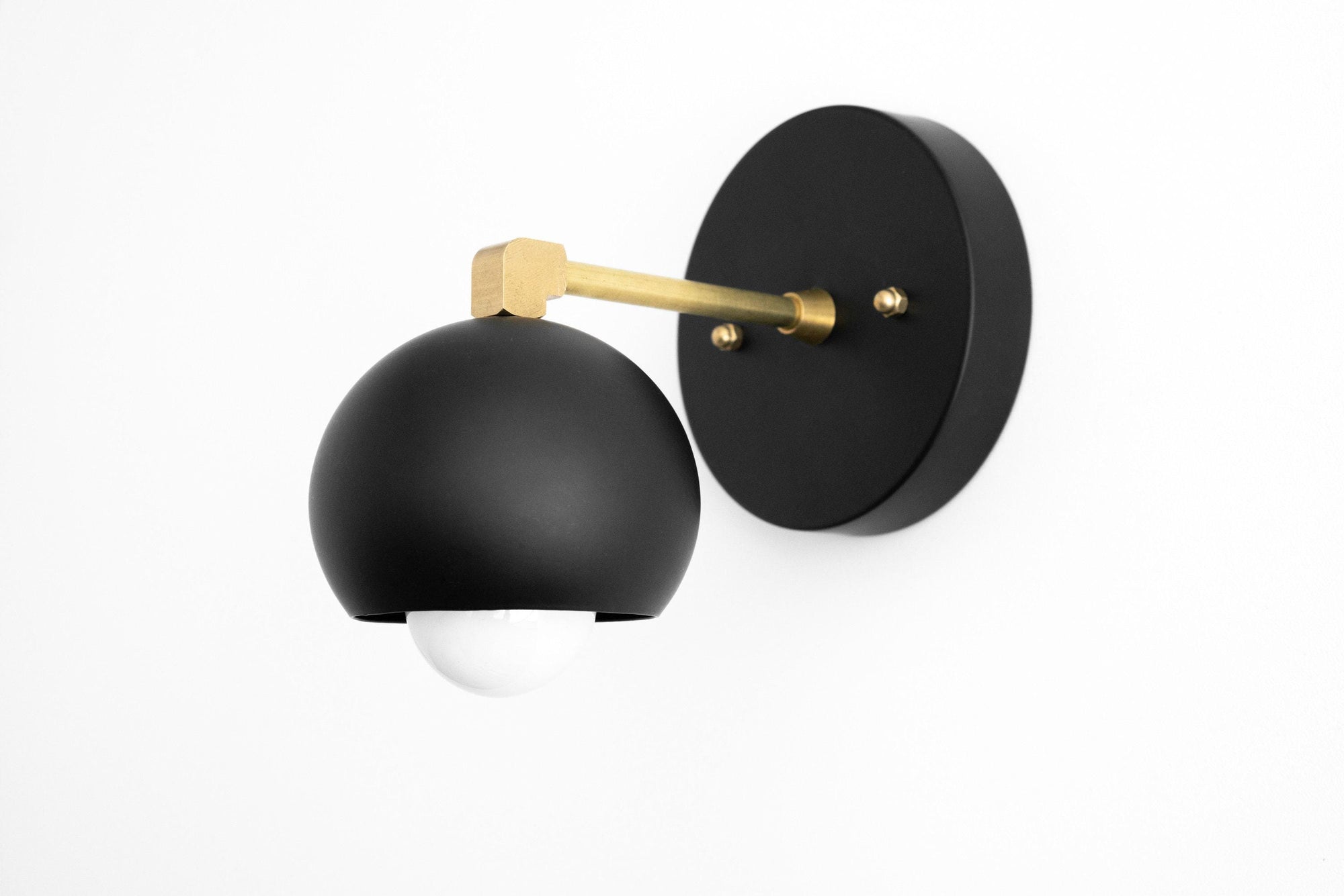 Black semi-flush wall sconce with curved shade and raw brass arm and mounting plate. - SCONCE MODEL NO. 0053