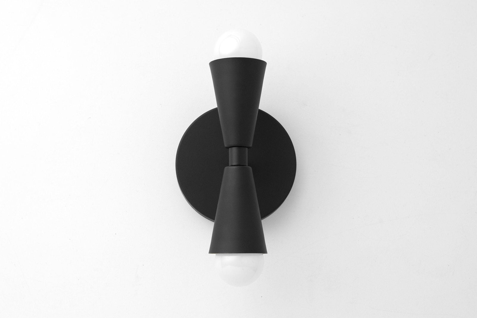 Mid-century modern black metal sconce with up/down exposed bulbs and round backplate. - SCONCE MODEL NO. 4717
