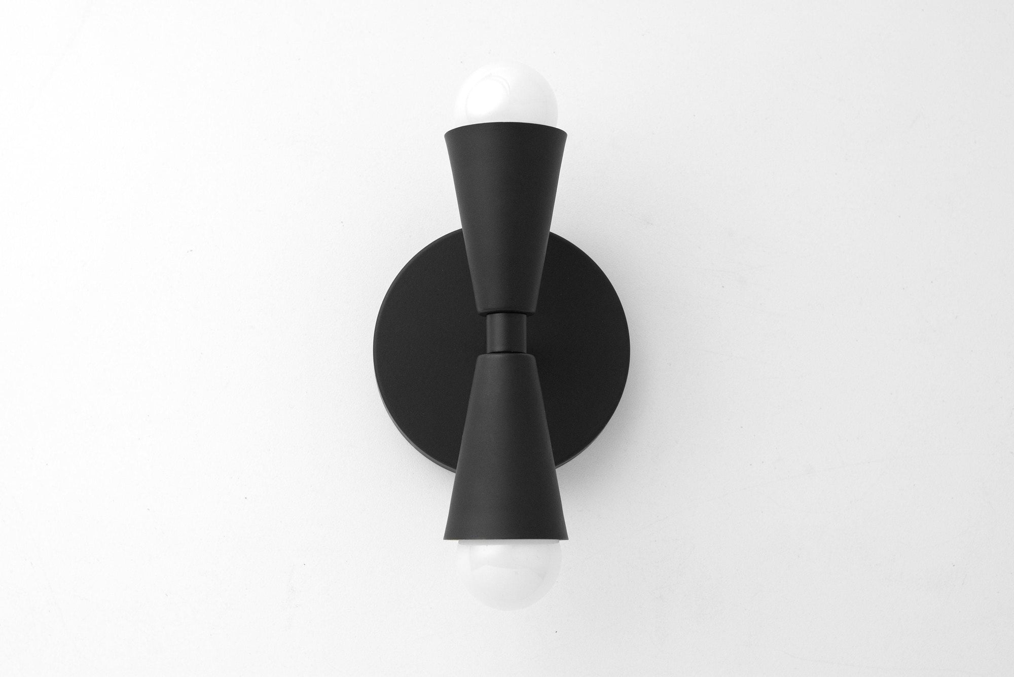 Mid-century modern black metal sconce with up/down exposed bulbs and round backplate. - SCONCE MODEL NO. 4717